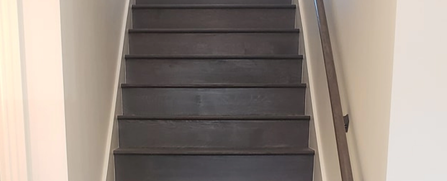wooden black stair and rail matched with white walls adger al